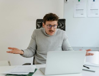 Un homme confus devant son ordinateur