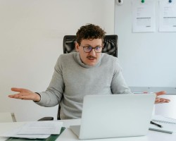 Un homme confus devant son ordinateur