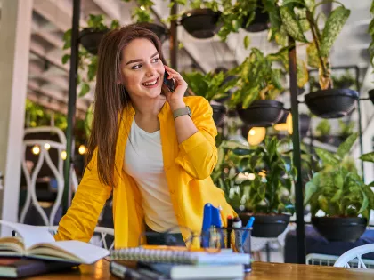 smiling-woman-speaking-by-mobile-phone-her-office
